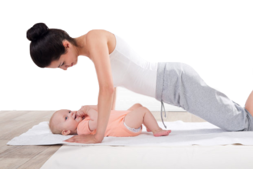 Jeune maman avec son bébé allongé sur des tapis.